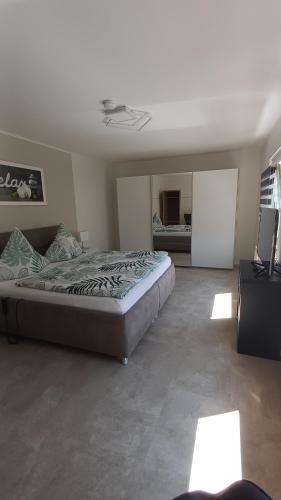 a bedroom with a large bed and a mirror at Ferienwohnung Römerweinhof in Neumagen-Dhron