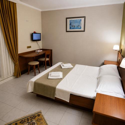 a bedroom with a bed and a desk with a computer at Doruk Hotel in Tıraça