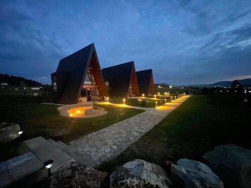 a large building with lights in front of it at night at Pensiunea La Bella Vista in Poiana Negrii