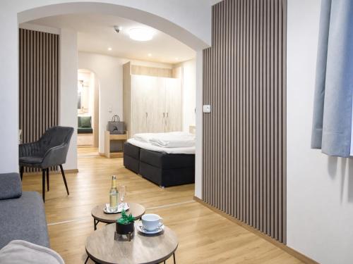 a bedroom with a bed and a living room at Hotel zur Linde - Bayerischer Wald - aktivCard mit 154 kostenfreien Leistungen - kostenloser Parkplatz in Lohberg