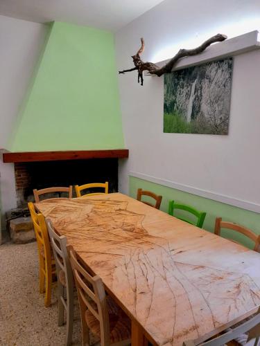a wooden table with chairs and a tree branch on the wall at Rifugio lo Schioppo in Morino