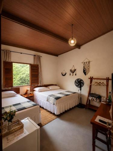 a bedroom with two beds and a window at Reserva do Bosque Hospedaria e Natureza in Ibicoara