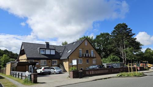a large house with cars parked in a parking lot at Pension Haus Erika in Cuxhaven