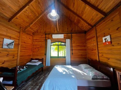 a bedroom with two beds in a log cabin at Chalé Alpino Apiúna in Apiúna
