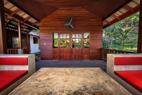 a room with a table and a wooden door at Flower Power Farm Village in Ko Phayam