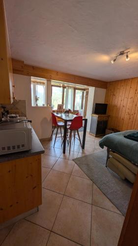 a kitchen and living room with a table and chairs at Petit studio à Lourtier in Lourtier