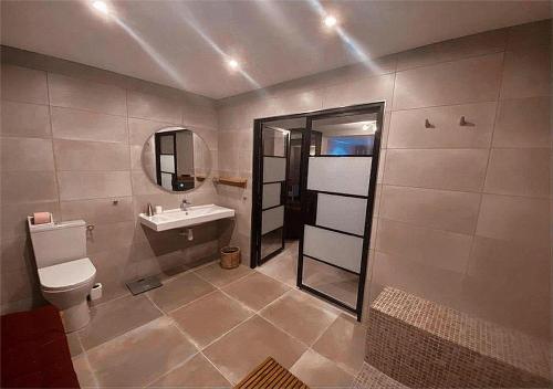 a bathroom with a sink and a toilet and a mirror at La perle rouge A Panazol in Panazol