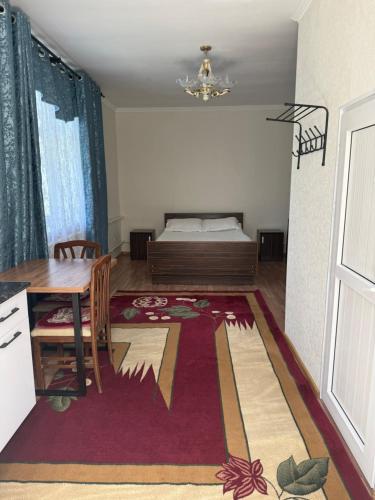 a room with a bed and a table and a dining room at Yhome in Karakol