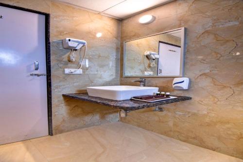a bathroom with a sink and a mirror at Hotel Bhagyalaxmi NX in Shirdi