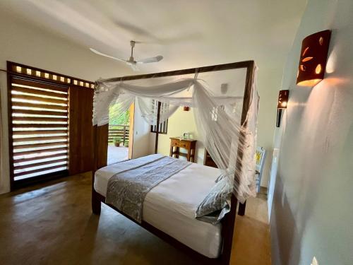 a bedroom with a bed with a canopy at Casa Monte Pacífico, jacuzzi, wifi Starlink y vista al mar in San Agustinillo