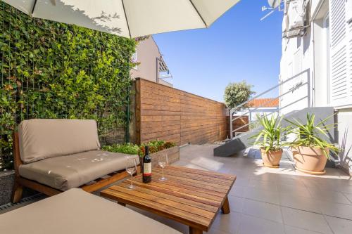 a patio with a wooden table and a bench at Apartments 2A in Petrcane