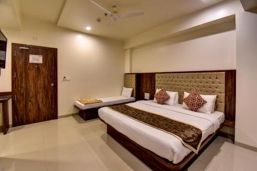 a hotel room with a large bed and a desk at Hotel Bhagyalaxmi NX in Shirdi
