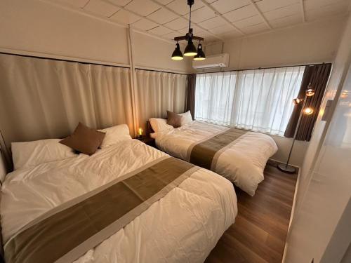 a bedroom with two beds and a window at koharubi hanada in Murochō