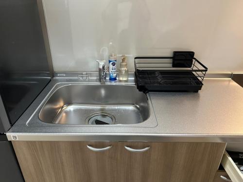 a kitchen counter with a stainless steel sink at koharubi hanada in Murochō