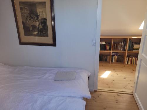 a bedroom with a bed with a picture on the wall at Lejbølle gamle Bageri værelse 2 in Bøstrup