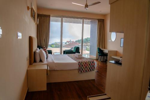 a hotel room with a bed and a large window at Luxe Vista Resort Kodai in Kodaikānāl