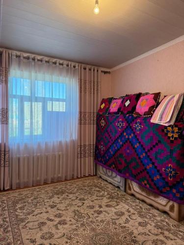a bedroom with a bed and a window at Ayara home in Kyzart