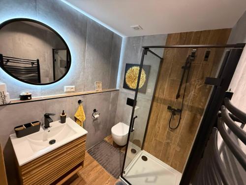 a bathroom with a shower and a sink and a mirror at Apartmán 504 Svit in Jezersko