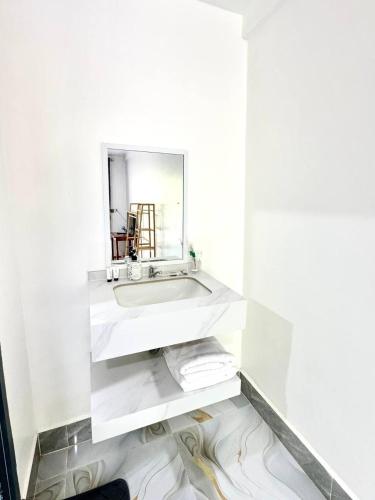 a white bathroom with a sink and a mirror at Garden Hostel Koh Rong in Koh Rong Island