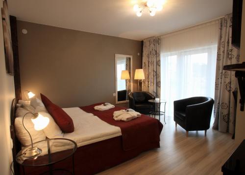 a hotel room with a bed and chairs and a window at Vejby Strand Hotel in Vejbystrand