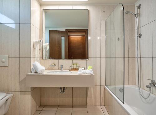 a bathroom with a sink and a shower and a mirror at Blue Lagoon Resort in Lampi