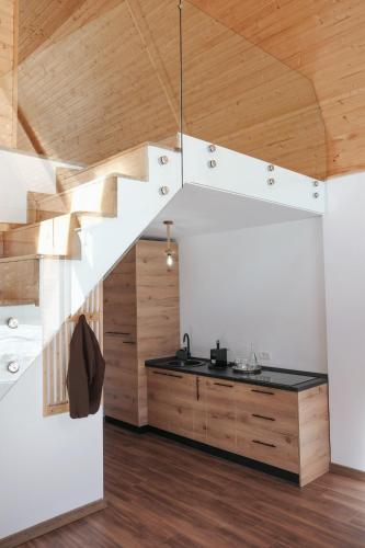 a kitchen with white walls and wooden ceilings at Chalets by Hotel Transalpin in Obarsia-Lotrului