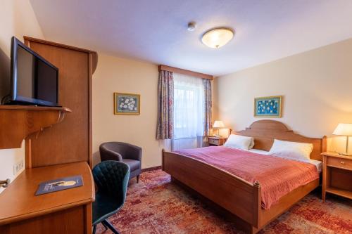 a hotel room with a bed and a flat screen tv at Hotel-Pension Schwaighofen in Eugendorf