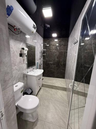 a bathroom with a white toilet and a shower at Mamura Karimova in Andizhan