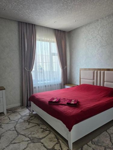 a bedroom with a large bed with a red blanket at Mamura Karimova in Andizhan