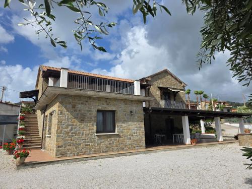 a brick house with a balcony on top of it at Country House Il Melograno in Castellabate