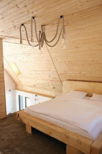 a bedroom with a large bed with a wooden ceiling at Chalets by Hotel Transalpin in Obarsia-Lotrului