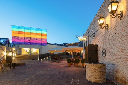 a brick patio with tables and umbrellas at night at Hotel Varde Garten in Varde