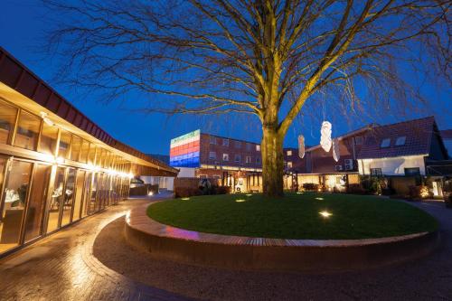 a tree in the middle of a courtyard at night at Hotel Varde Garten in Varde
