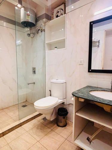 a bathroom with a toilet and a glass shower at Hotel Four Season - Gomtinagar - Lucknow in Lucknow