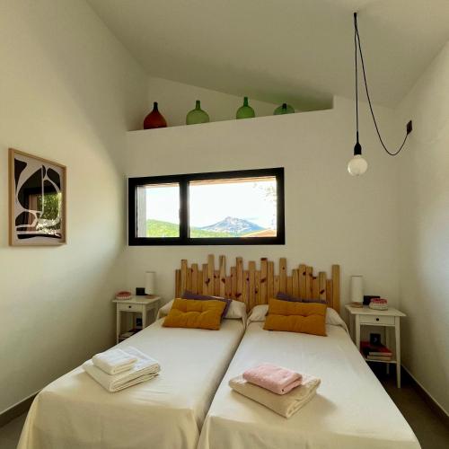 a bedroom with two beds and a window at Los Castaños in La Alberca