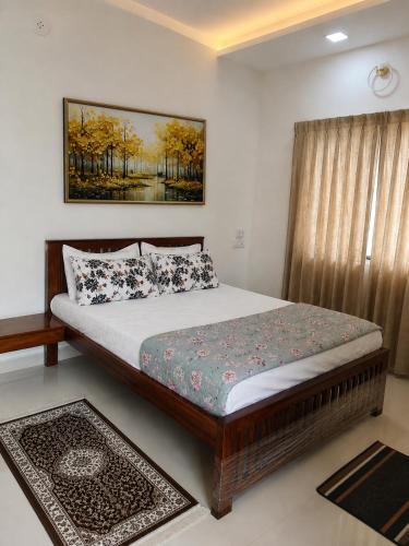 a bedroom with a bed and a picture on the wall at Wale's Hilltop Villa in Kolhapur