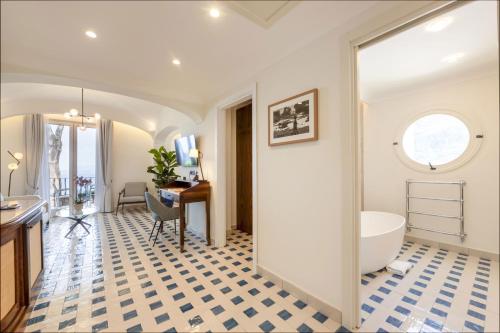 a bathroom with a tub and a sink and a desk at San Montano Resort & Spa in Lacco Ameno