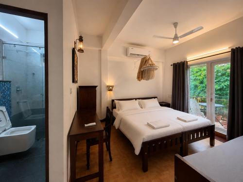 a bedroom with a bed and a bathroom with a tub at Reds Residency - Homestay in Cochin