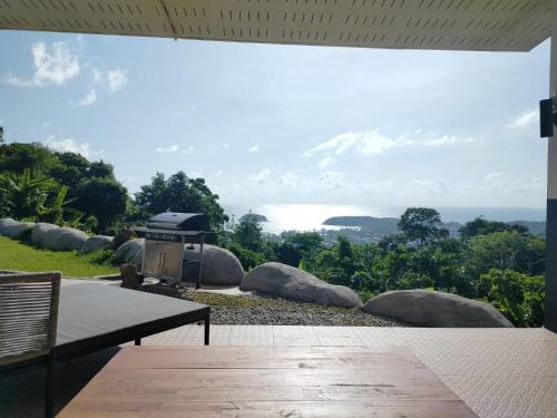 a patio with a grill and a view of the ocean at Villa Olympus Sea View Private Pool 4BR Near Kata Beach in Kata Beach