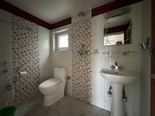 a bathroom with a white toilet and a sink at Rock Garden Resort in Pokhara