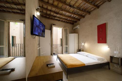 a bedroom with a bed and a flat screen tv at Secret B&B in Trapani