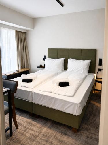 a bedroom with two beds with white sheets at The 8 Hotel Budapest in Budapest