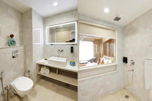 a bathroom with a toilet and a sink and a mirror at Hotel Shambhu Narayan G K Group Varanashi in Varanasi