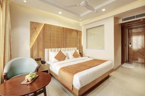 a hotel room with a bed and a table and a chair at Hotel Shambhu Narayan G K Group Varanashi in Varanasi