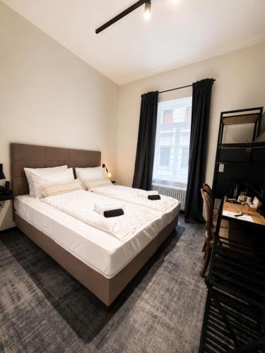 a large white bed in a room with a window at The 8 Hotel Budapest in Budapest