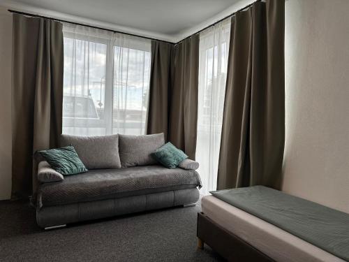 a living room with a couch in front of a window at Modernes Studio mit Küche, WLAN, Parkplatz in Dingolfing