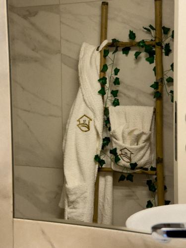 a mirror in a bathroom with a white robe on a shelf at Casinha do Orjal in Ponte de Lima