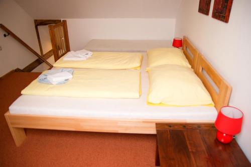 two beds in a small room with yellow pillows at Vila Pod Bránou in Poprad