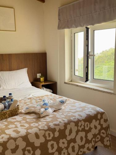 a bedroom with a bed with towels and a window at Casinha do Orjal in Ponte de Lima