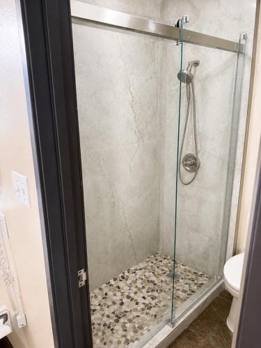 a shower with a glass door in a bathroom at Four Winds Motel & RV Park in Carrizozo